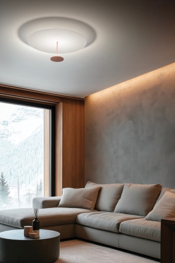 Wohnzimmer mit Sofa und Fensterfront, an der Decke eine flache, runde Deckenleuchte Stilo von Linea Light