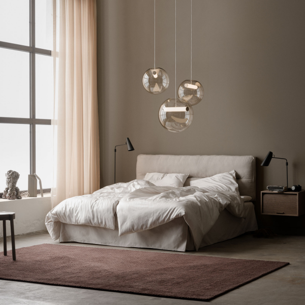 Schlafzimmer mit Pendelleuchten Reveal und einer Leseleuchte Birdy am Bett