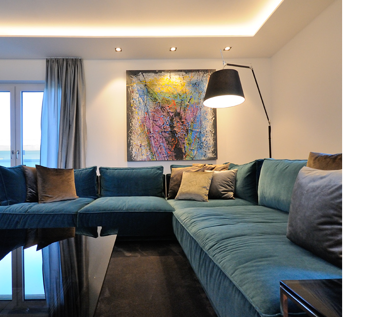 Sofaecke am Abend mit Bogen-Stehleuchte und warmem Licht von der Seite