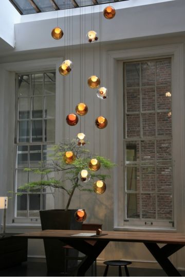 Kupferfarbene Hängeleuchte Melt Mini Chandelier von Tom Dixon über einer hellen Treppe